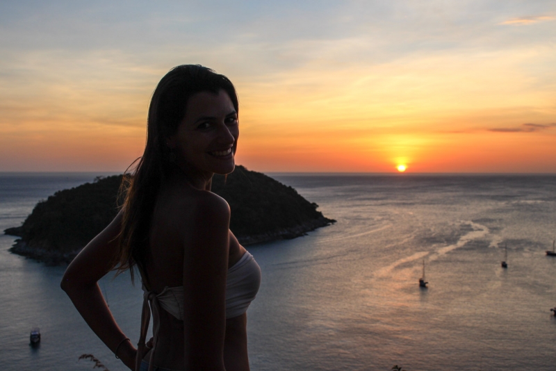 Woman watching the sunset in Phuket, one of the best things to do in Phuket.