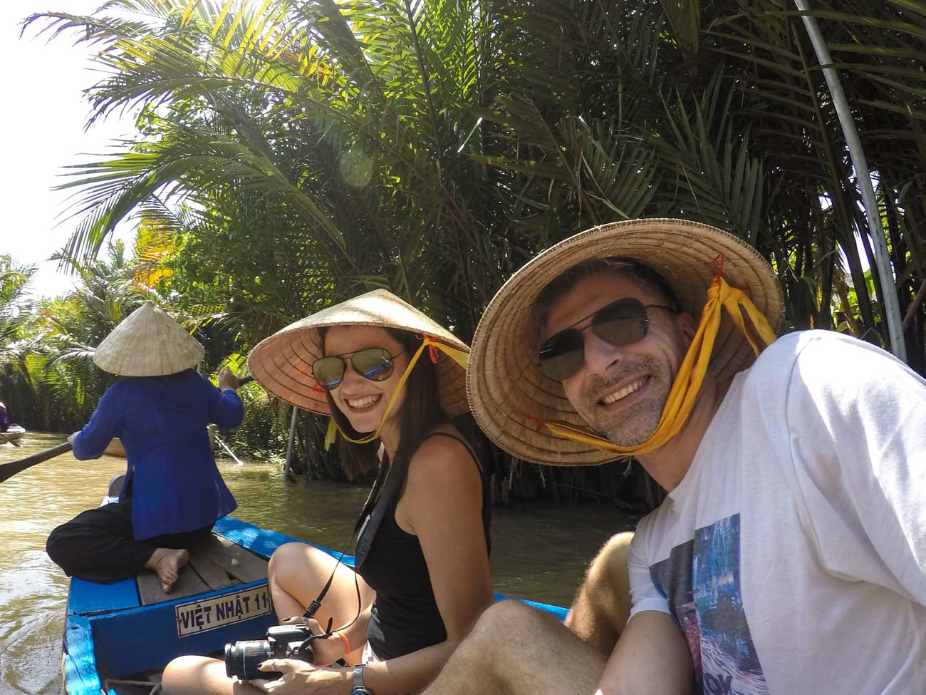 A couple on a boat. They are on a Mekong Delta Tour, a famous day trip from Ho Chi Minh city.