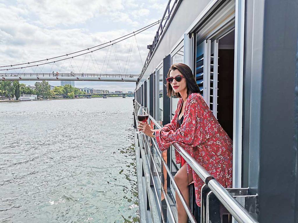 Mulher viajante desfrutando taça de vinho em cruzeiro no Rio Reno na Alemanha.