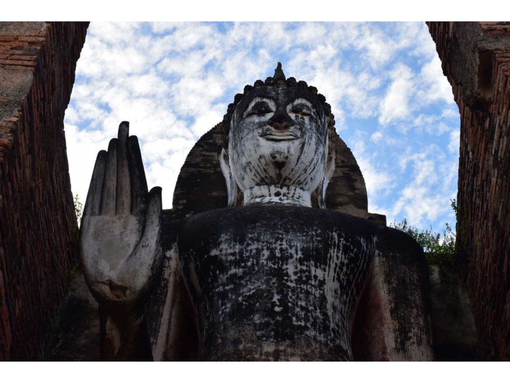 Buda em pé no topo do templo de Wat Saphan Hin, no Parque Histórico de Sukhothai, uma caminhada interessante que você deve fazer em Sukhothai.