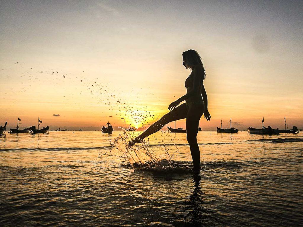 Mulher sobre a água visitando as melhores praias de Koh Tao.