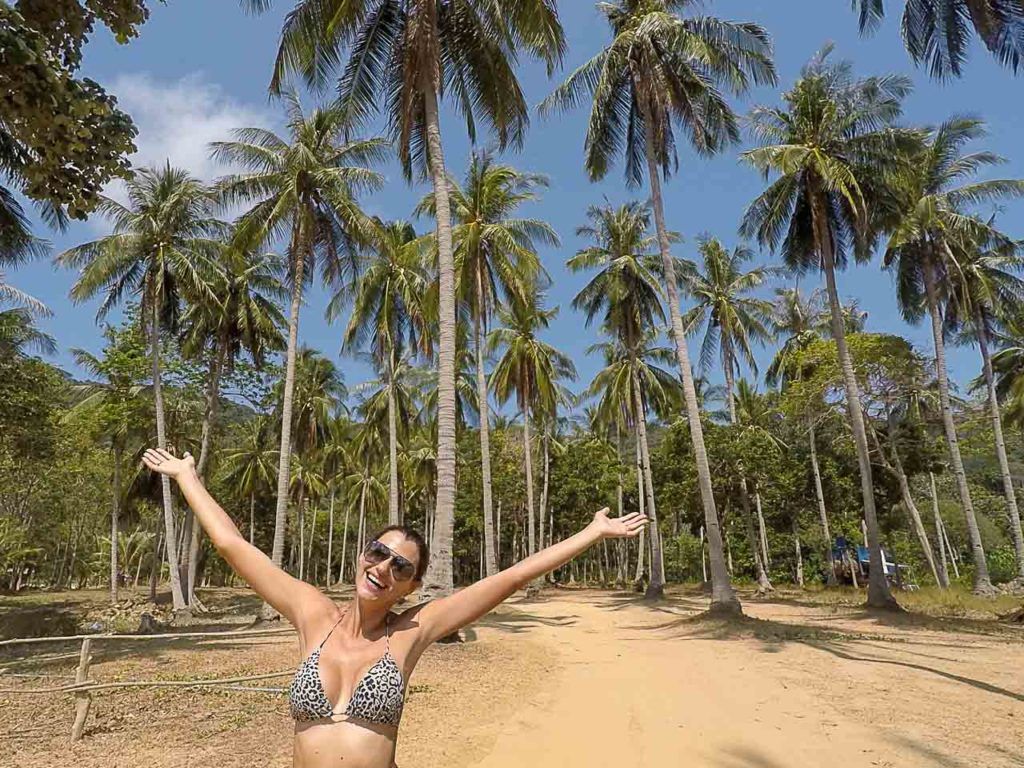 Mulher feliz entre palmeiras de Koh Lanta.