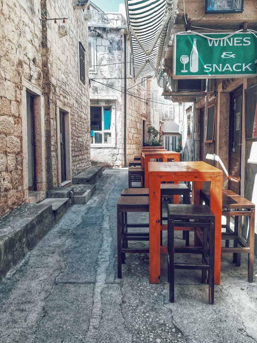 Korčula Island is famous for its food and wine. The photo shows a few outdoor tables in front of a local Croatian restaurant. 
