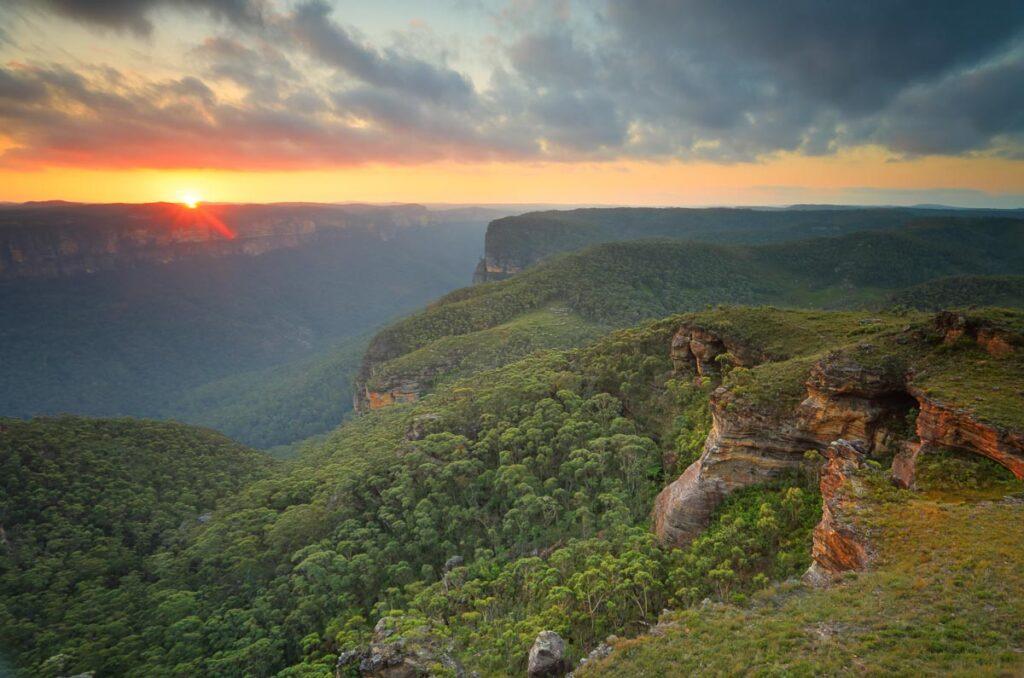 The sun sets in the west over the Grose Valley and  Blue Mountains from Mt Banks.