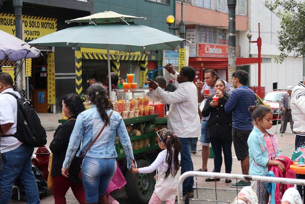 A street vendor selling fruit juices on a busy street in Bogota, Colombia.