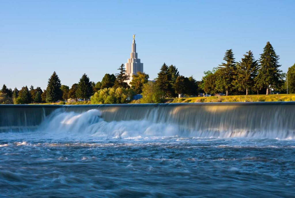 Photo of the Snake River in Idaho Falls, with a small cascade of water. Many of Idaho Falls attractions are near the river.