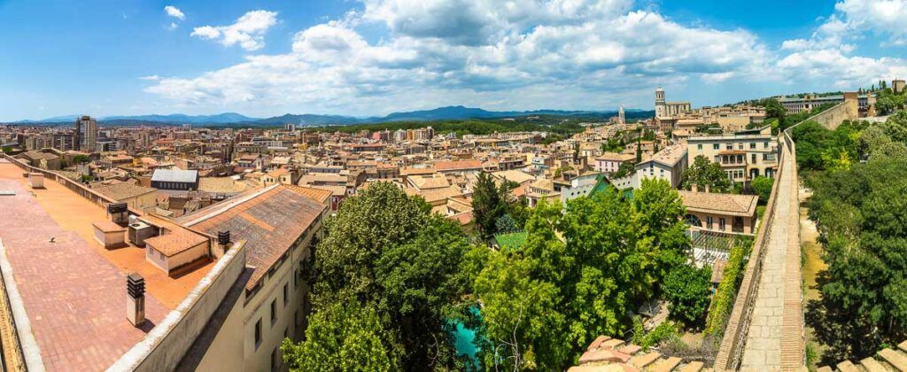 Beautiful view from Girona Medieval Walls. It shows the city in the background and the mountains. The Walls are one of the reasons to visit Girona in Spain.  