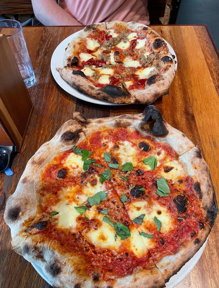 Two pizzas served with a local beer in Portland. The city is famous for its beer scene and many brewery tours in Portland.