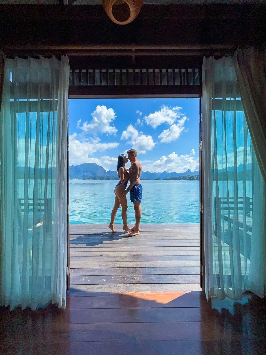 A couple standing on the balcony of a floating hotel in Khao Sok.