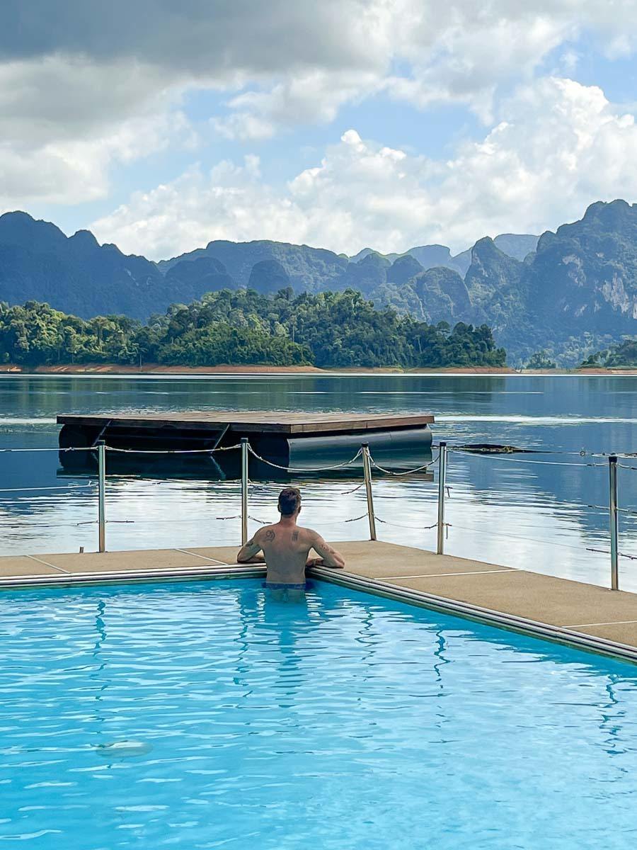 A man relaxing at the hotel pool. the is in the middle of the Khao Sok lake with beautiful views of the mountain and lake.