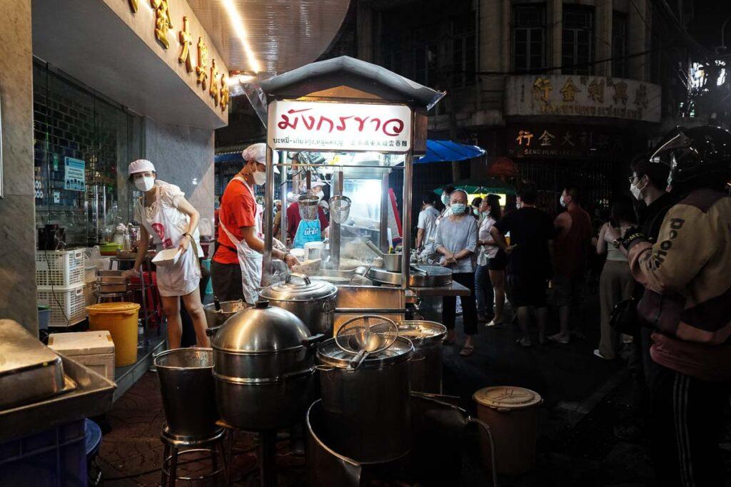 Vendedor ambulante movimentado em Chinatown. A fila de espera pela comida mostra que os pratos são frescos e deliciosos. É bom considerar isso se você quiser comer com segurança em Bangkok.