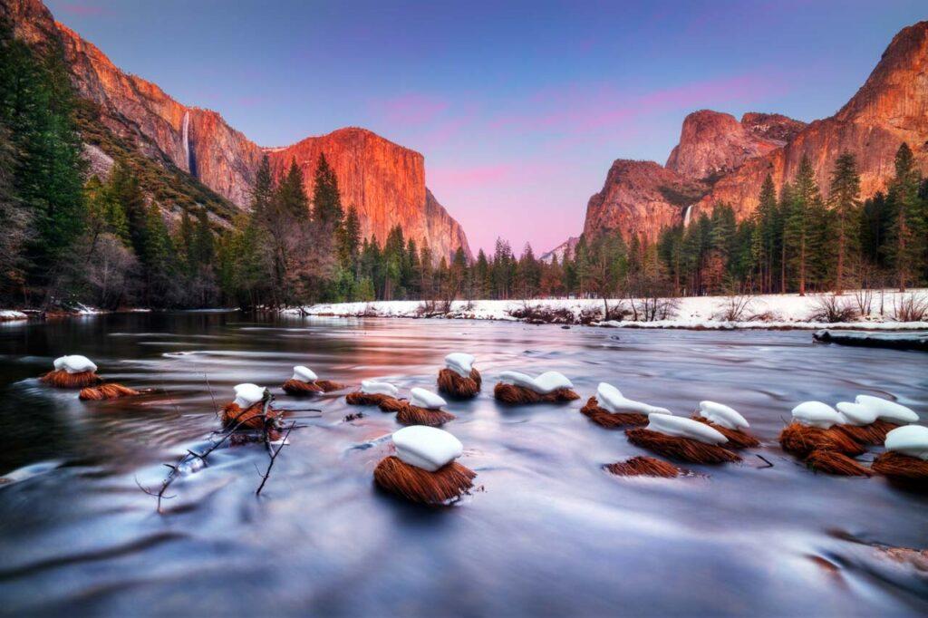 Long exposure photo of a lake in Yosemite National Park on the west cost US. It' shows the rocky mountain in the background.