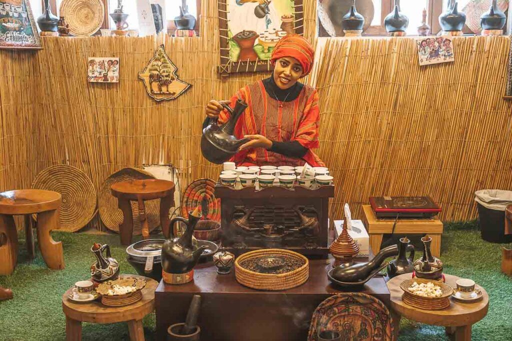 A woman is preparing coffee in the Dubai Coffee Museum which is a hidden gem in Dubai.