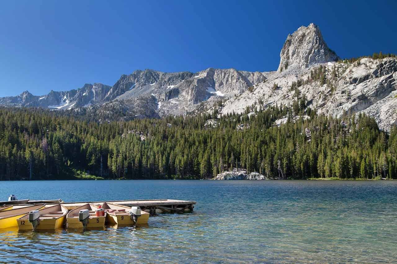 Lake George at Mammoth Lakes, Mono County, California, USA. The photo shows a lake with small boats and the rocky mountains in the back. 