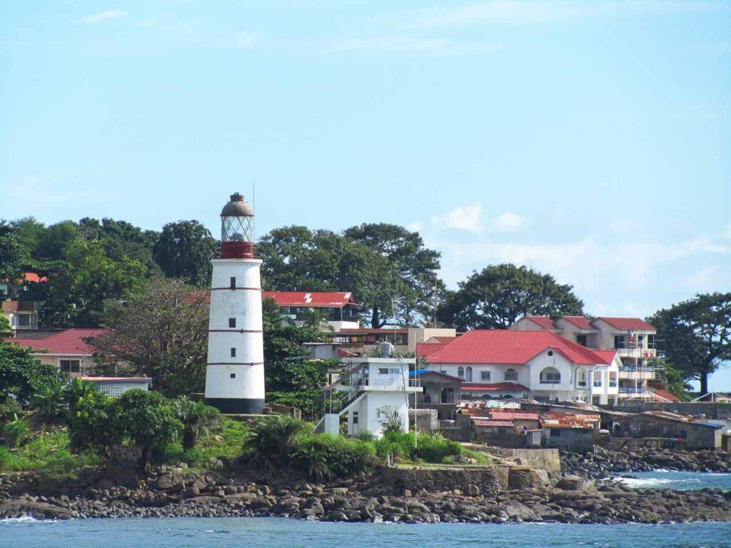 A view of houses and a lighthouse overlooking the sea in Freetown, Sierra Leone, Africa.