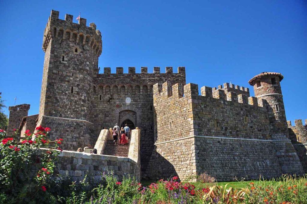 Photo of Castello di Amorosa in Napa Valley, California. It shows the castle entrance with a long staircase and the stone walls.