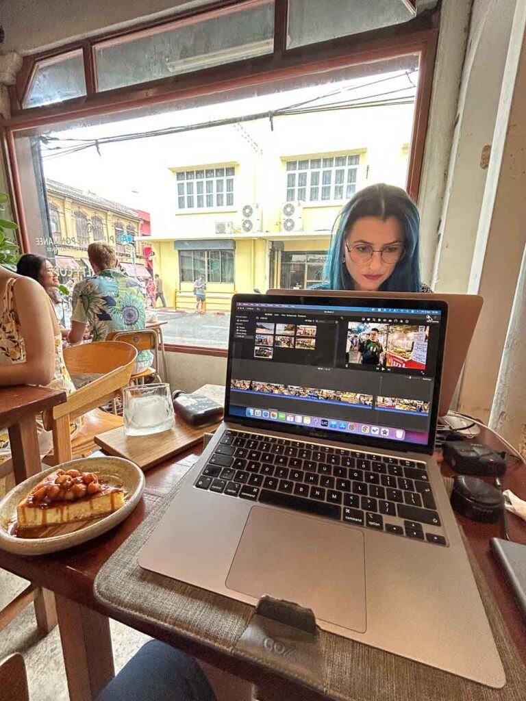 Woman working in a cafe. She is a digital nomad working as a writer and content creator
