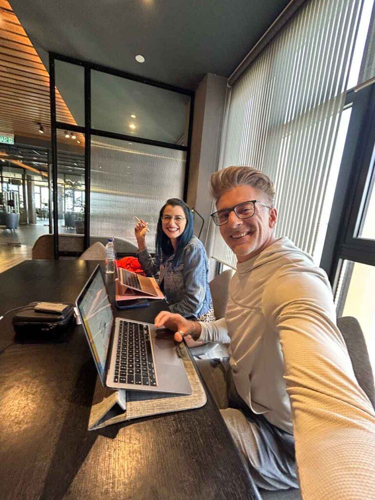 Photo of a woman and man working with their laptops from a coworking space.