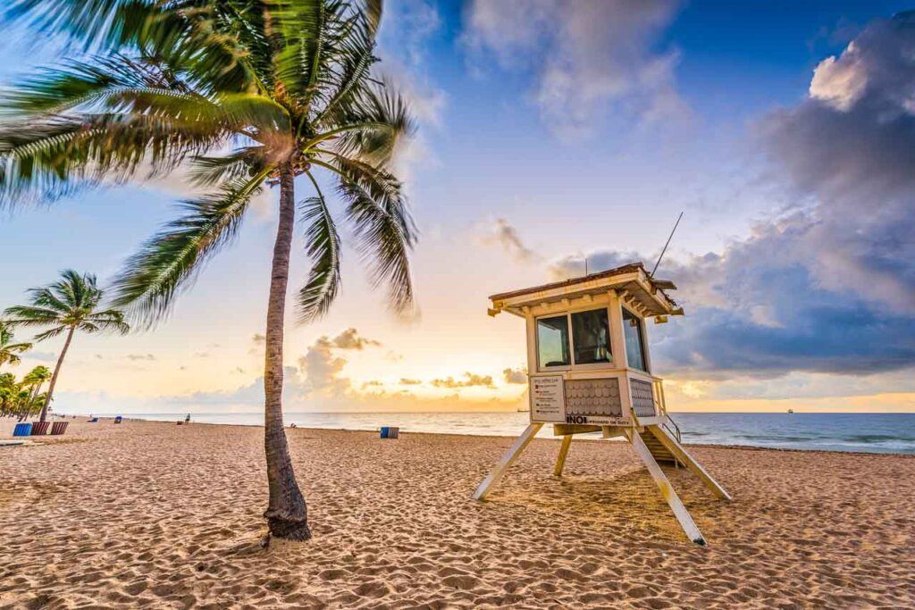 Photo of a beach with a lifeguard house and palm trees at Fort Lauderdale Beach, Florida, USA.