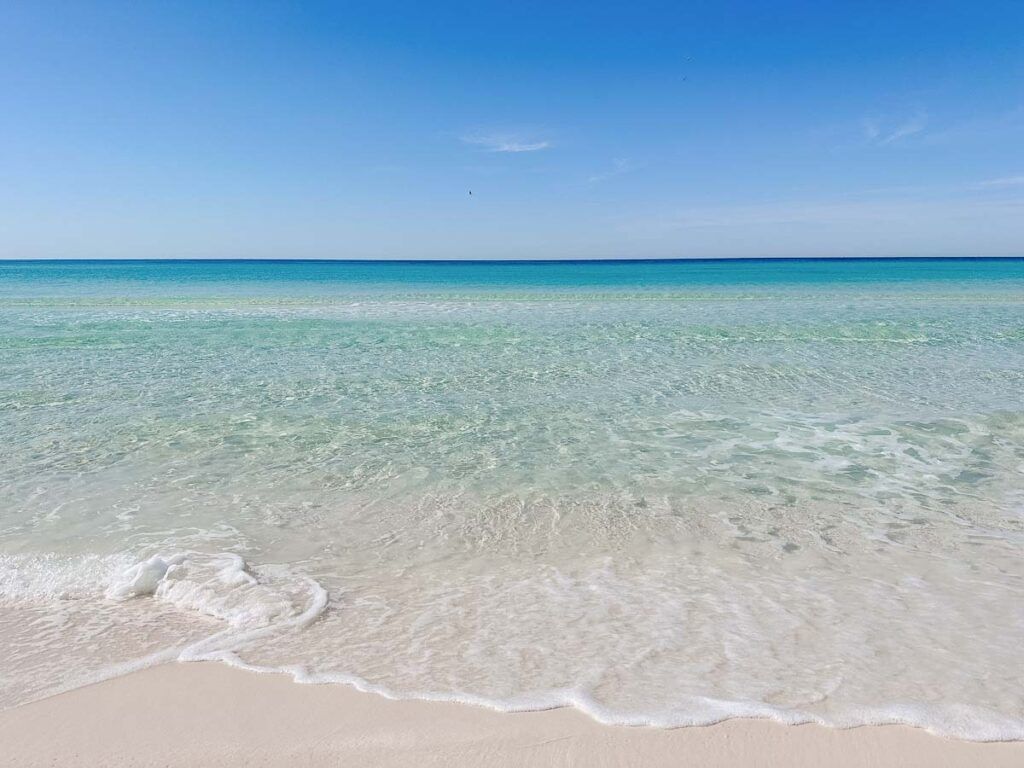 Pensacola Beach is a fabulous weekend getaway in Florida. The photo shows crystal clear water on a white sand beach.