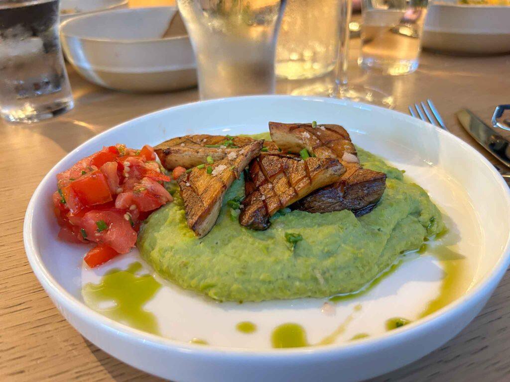 Plate with pea pure and grilled mushrooms. This dish was served in a locally sourced restaurant in Graz. Local organic food is one of the pillars of sustainable travel. 