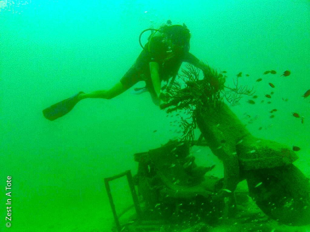 Person scuba diving in the Andaman Islands where she found a scooter underwater covered in corals. 
